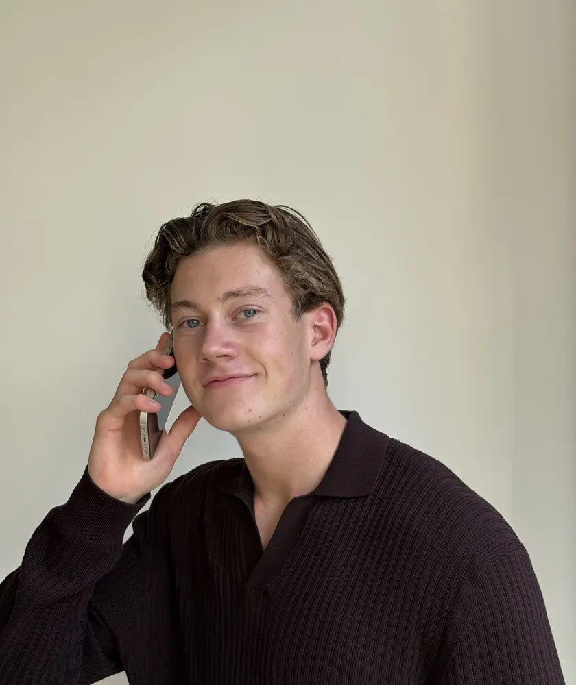 Maurits, oprichter van Flowvale, aan de telefoon voor een lichte muur.